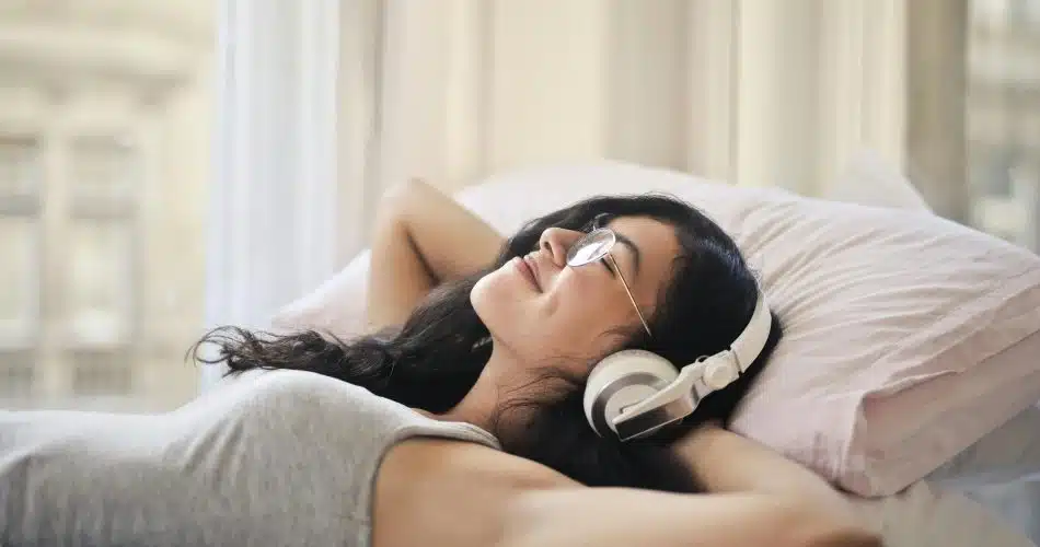 Moteris lovoje klausosi muzikos per "Spotify